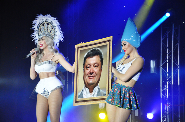 Оля Полякова выступает на сцене с портретами Порошенко и Кличко